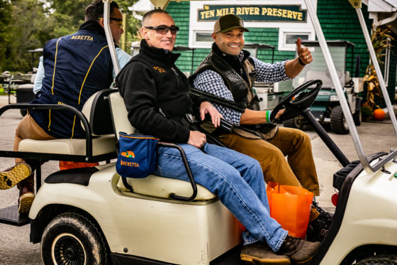 Smiling men in golf cart giving thumbs-up