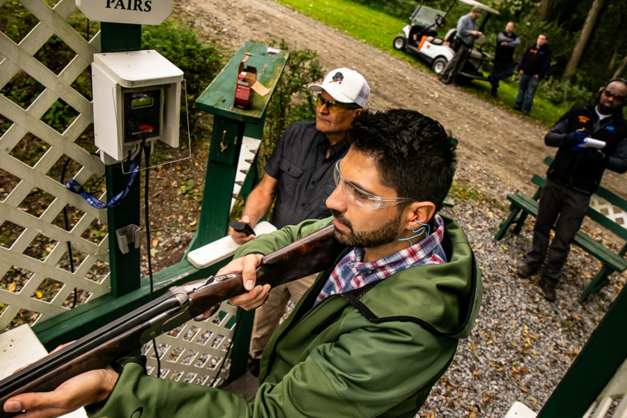 Man aiming shotgun at clay shooting range