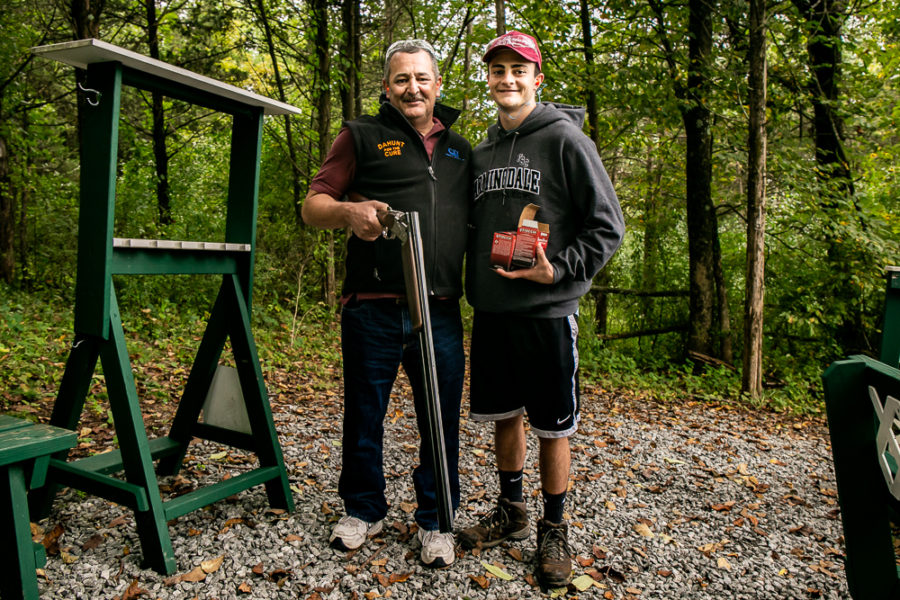 Two men smiling with shotgun and shells