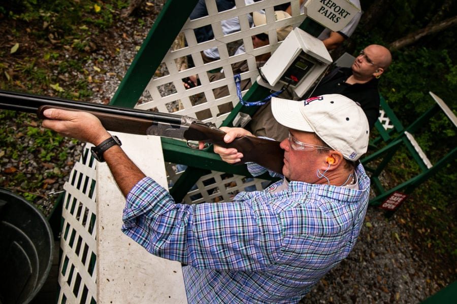 Man shooting shotgun at outdoor range
