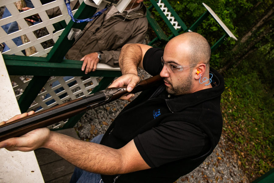 Shooter aiming shotgun at outdoor shooting range