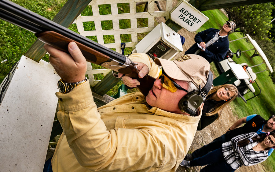 Person aiming shotgun at outdoor shooting range