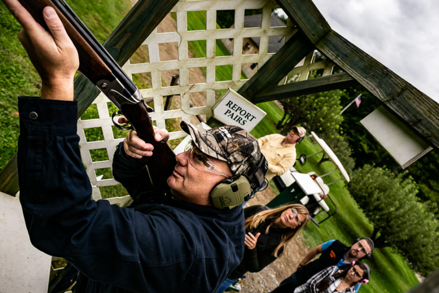 Man aiming shotgun at outdoor shooting range