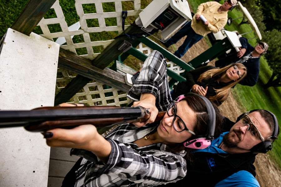 Woman aiming shotgun at outdoor shooting range