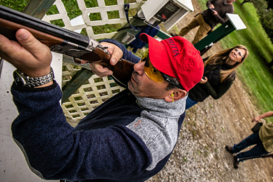 Person aiming shotgun at outdoor shooting range