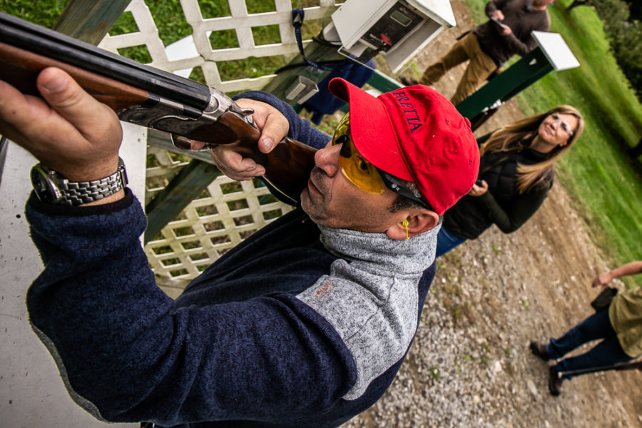 Person aiming shotgun at outdoor shooting range