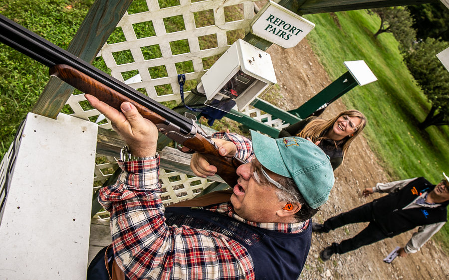 Man aiming shotgun at outdoor shooting range