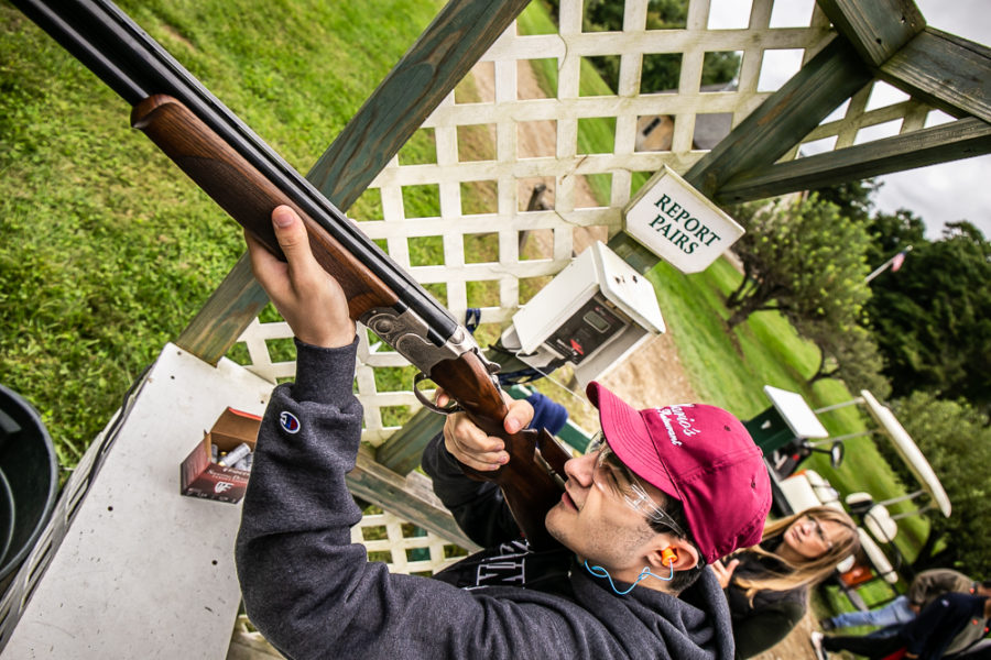 Person aiming shotgun at outdoor shooting range