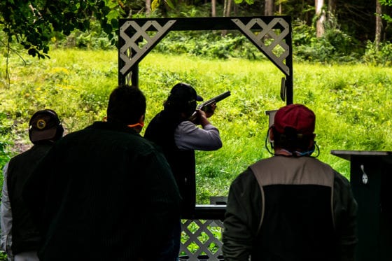 People skeet shooting at an outdoor range
