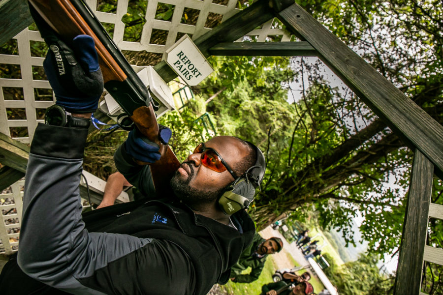 Man aiming shotgun at outdoor shooting range