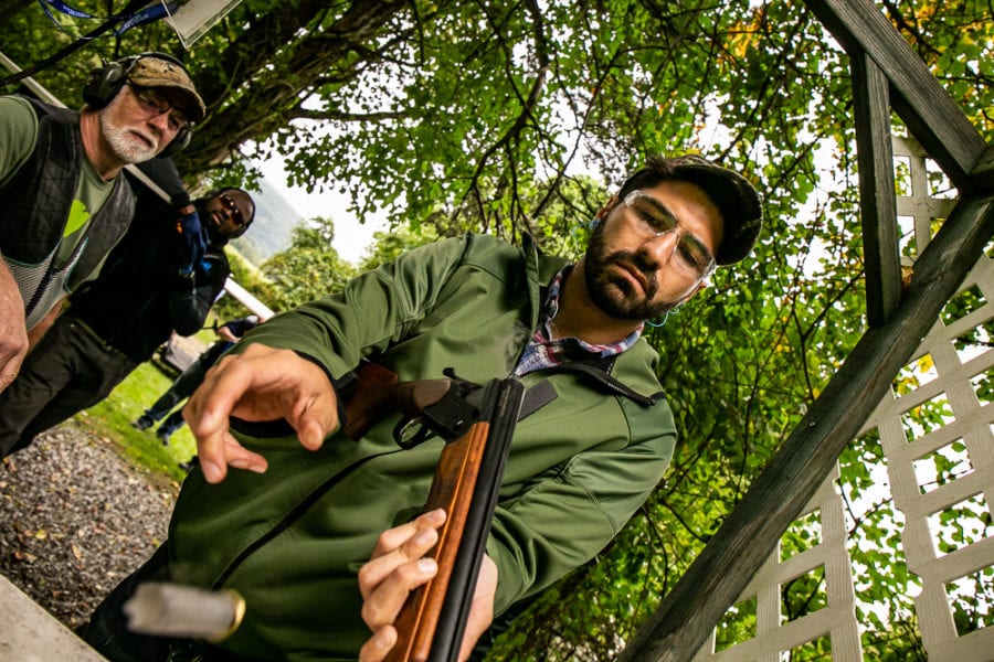 Man loading shotgun at outdoor shooting range