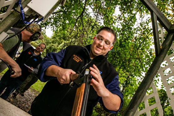 Man preparing shotgun at outdoor shooting range