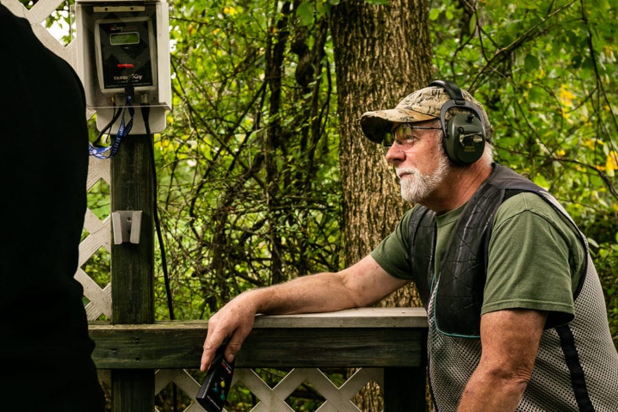 Bearded man with ear protection leaning on railing