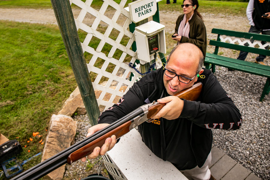 Man aiming over-under shotgun at clay range