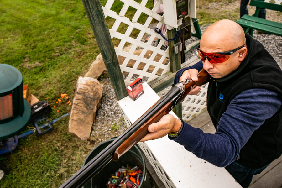 Person aiming shotgun at clay shooting range
