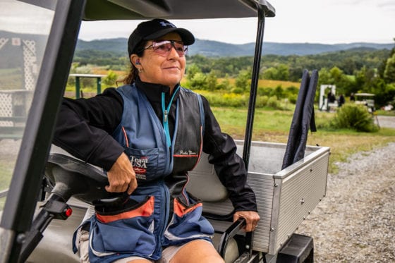 Woman wearing cap and sunglasses in golf cart