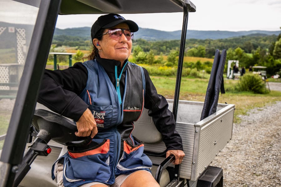 Woman wearing cap and sunglasses in golf cart