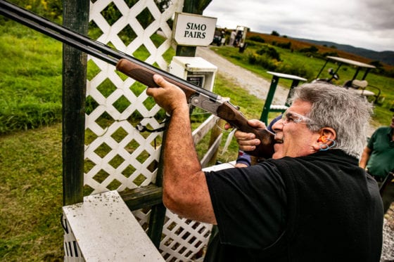 Person aiming shotgun at outdoor shooting range