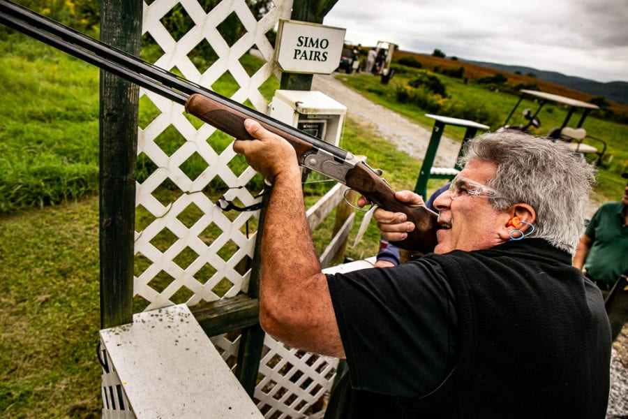 Person aiming shotgun at outdoor shooting range