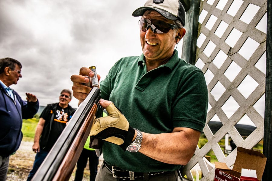 Smiling man loading shotgun at shooting range