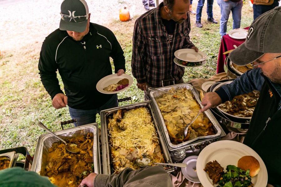 People serving themselves at outdoor buffet
