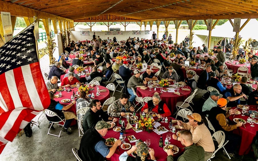 Crowd dining under pavilion with American flag