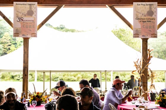 Outdoor fundraising luncheon under pavilion with banners
