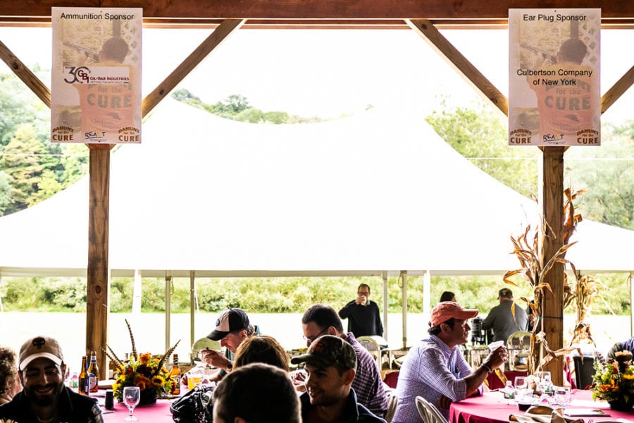 Outdoor fundraising luncheon under pavilion with banners