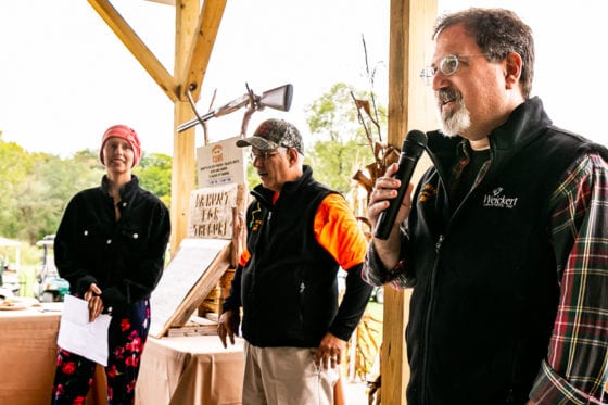 Man speaking into microphone at outdoor event