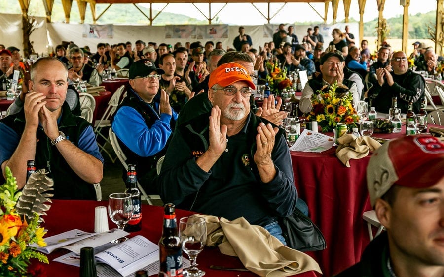 Attentive crowd applauding at banquet tables