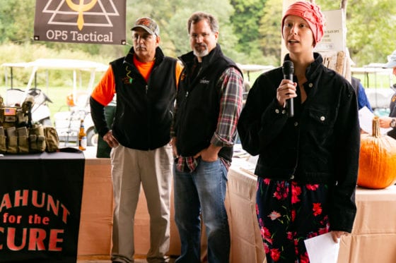 Woman speaking into microphone at outdoor fundraiser