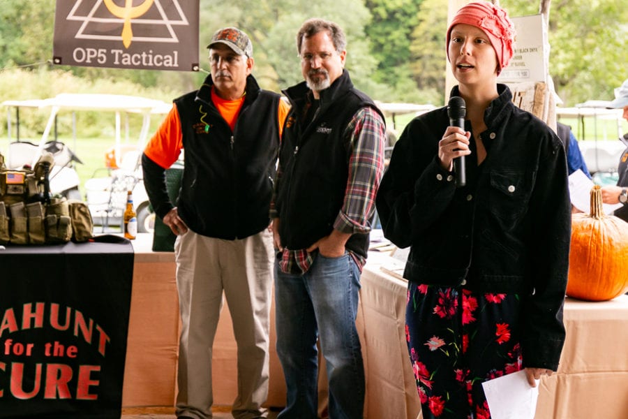 Woman speaking into microphone at outdoor fundraiser