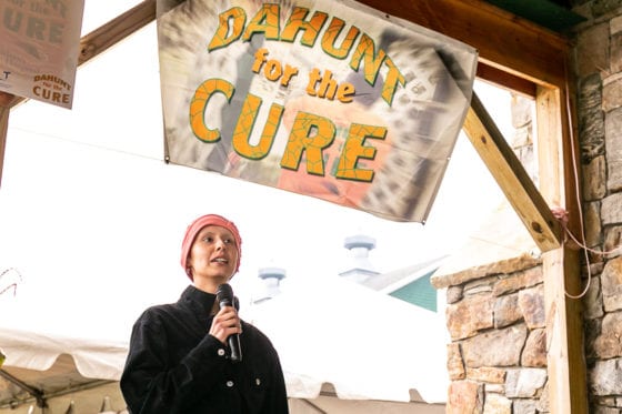 Person speaking at "Dahun for the Cure" banner