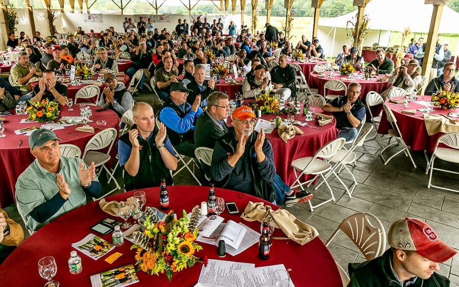 People applauding at outdoor luncheon with sunflowers