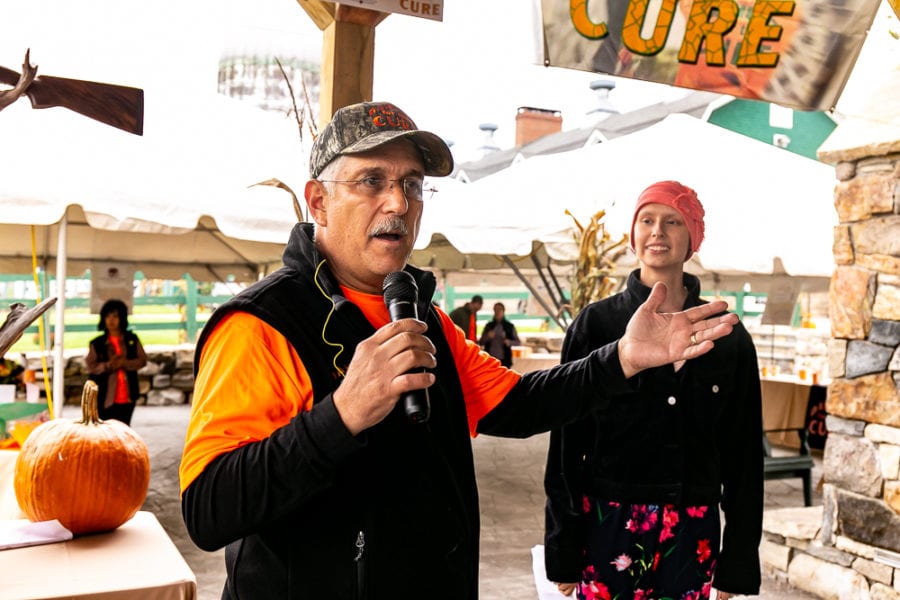 Man speaking into microphone at fall market