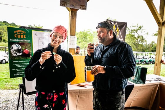 Two people tasting drinks under outdoor pavilion