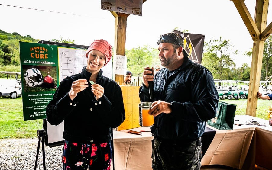 Two people tasting drinks under outdoor pavilion