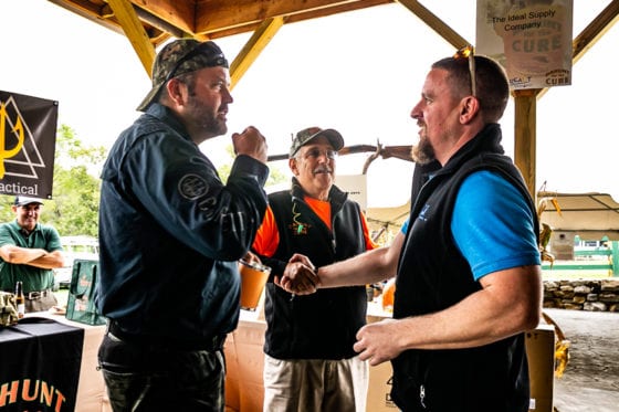Men shaking hands at outdoor vendor booth