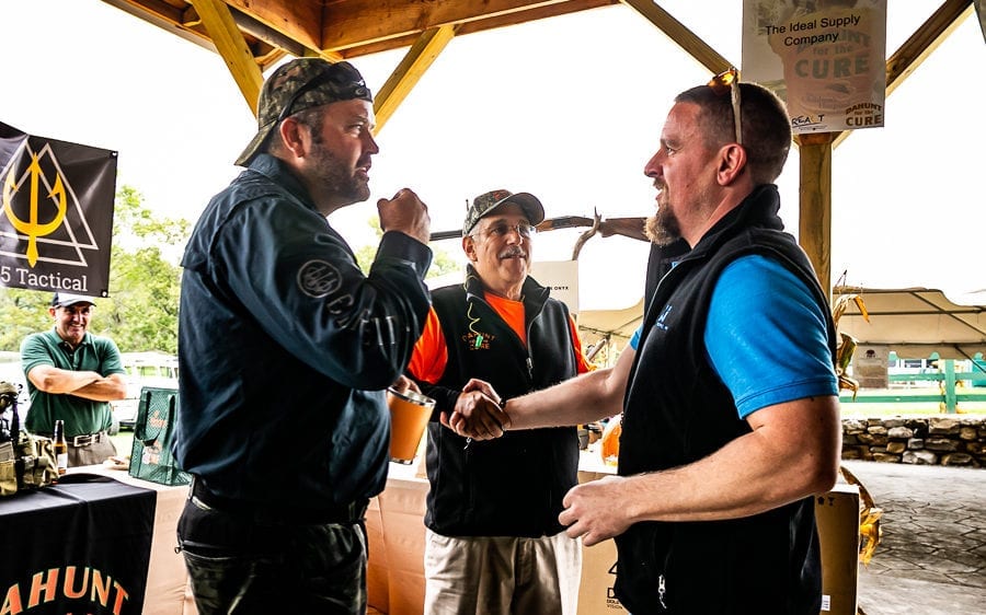 Men shaking hands at outdoor vendor booth