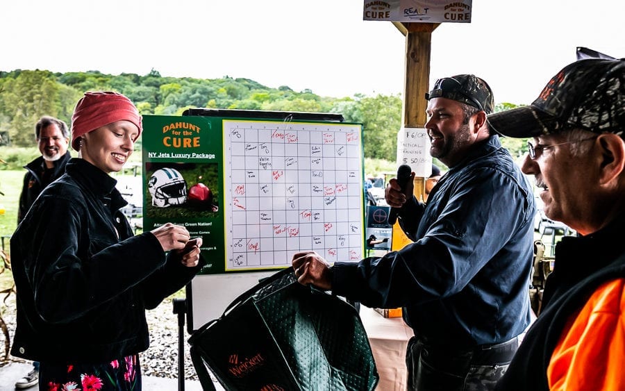 People marking board at outdoor community event