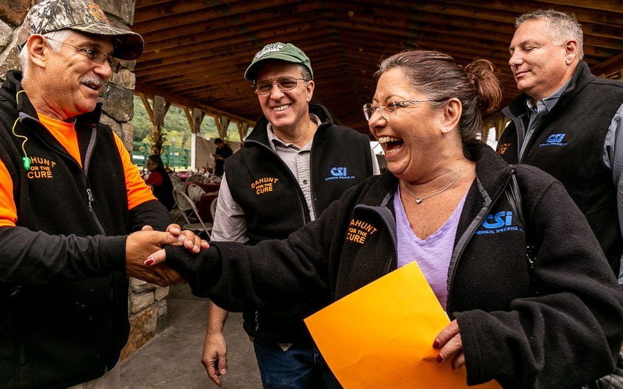 Smiling group exchanging handshake at outdoor pavilion