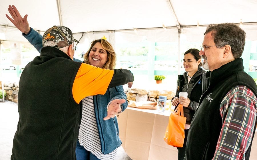 People exchanging hug at outdoor market tent