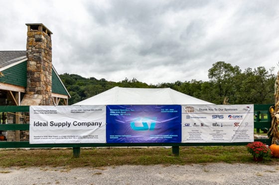 Event sponsor banners on green fence