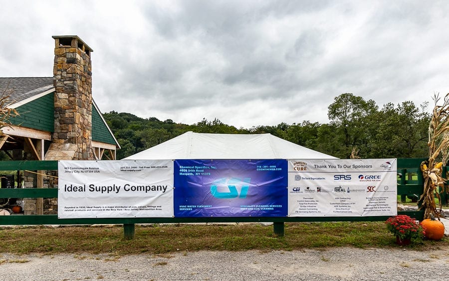 Event sponsor banners on green fence