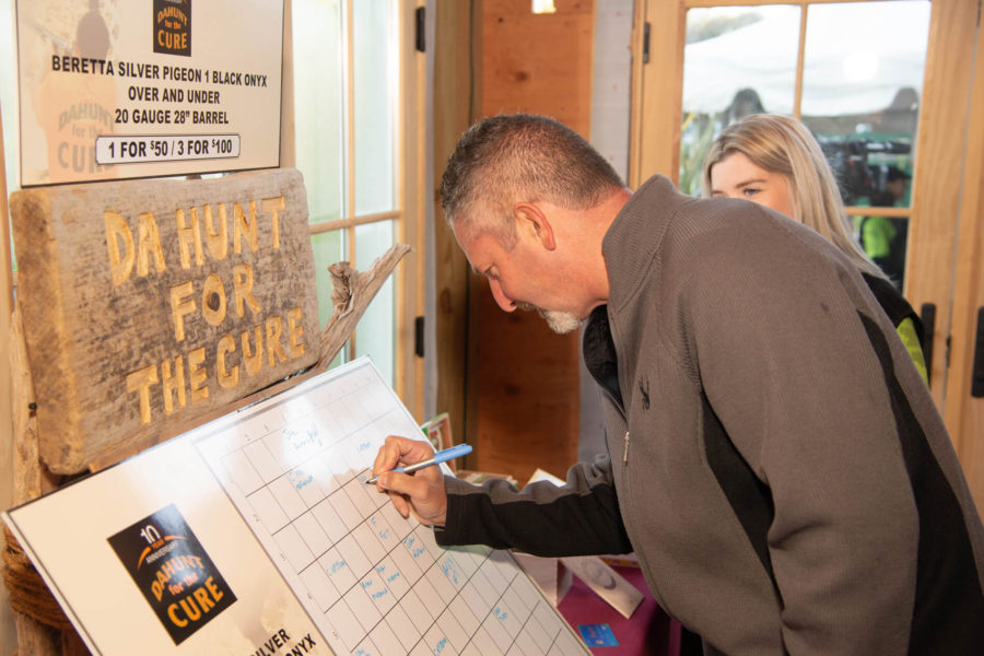 Person signing charity "Hunt for the Cure" board