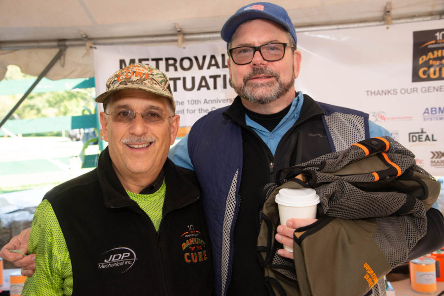 Two smiling men posing at outdoor event