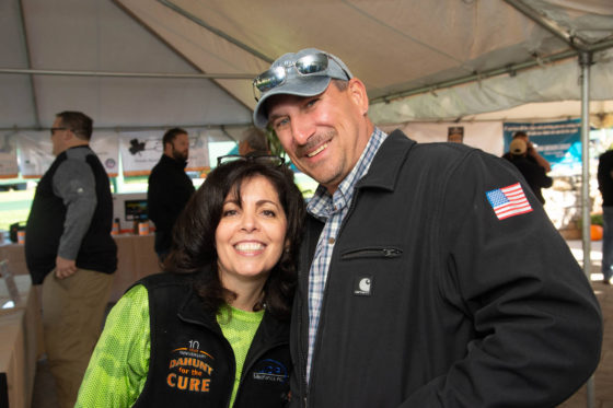 Smiling couple posing at tented outdoor event