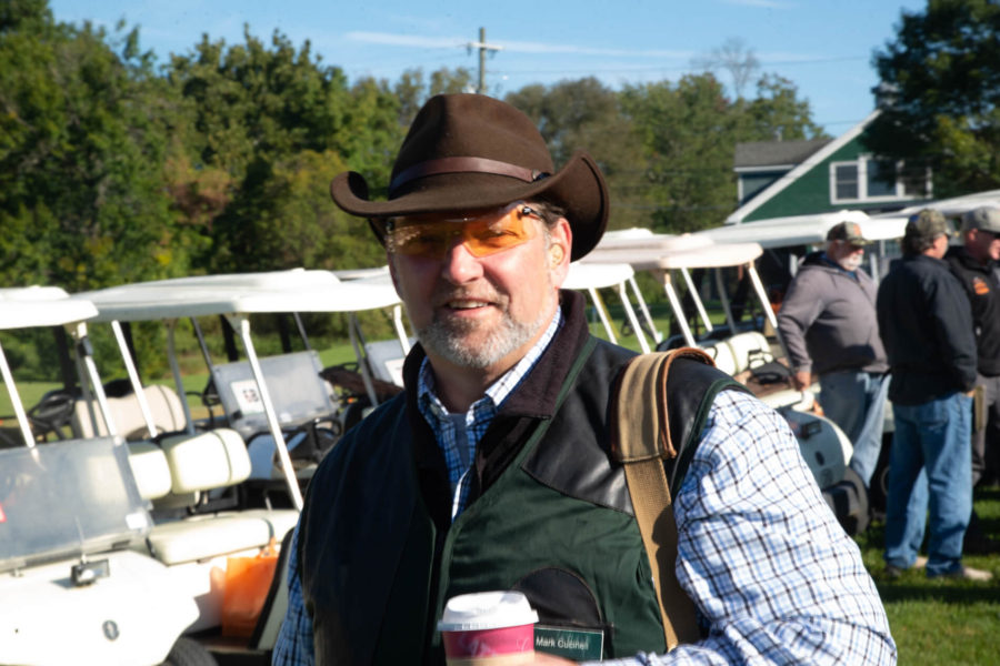 Man wearing cowboy hat and holding coffee