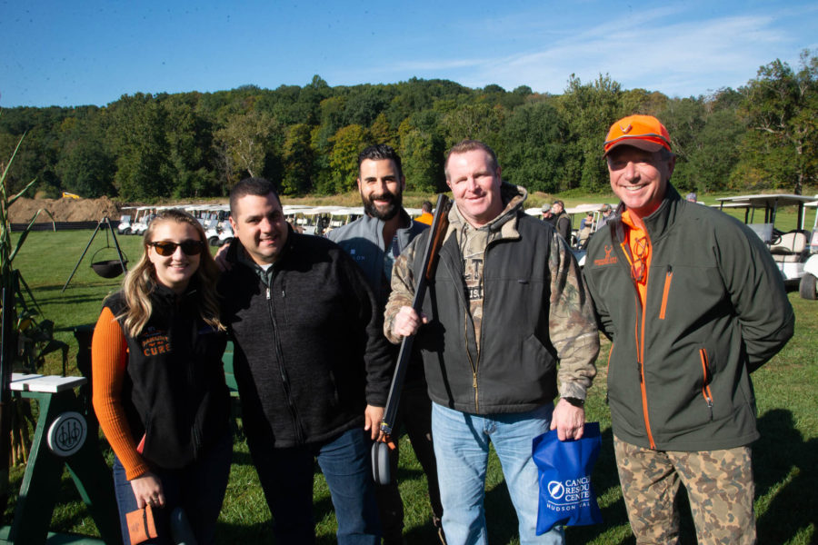 Five people smiling at outdoor shooting event