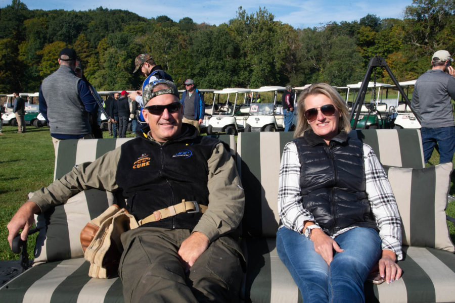 Two people on striped bench with golf carts